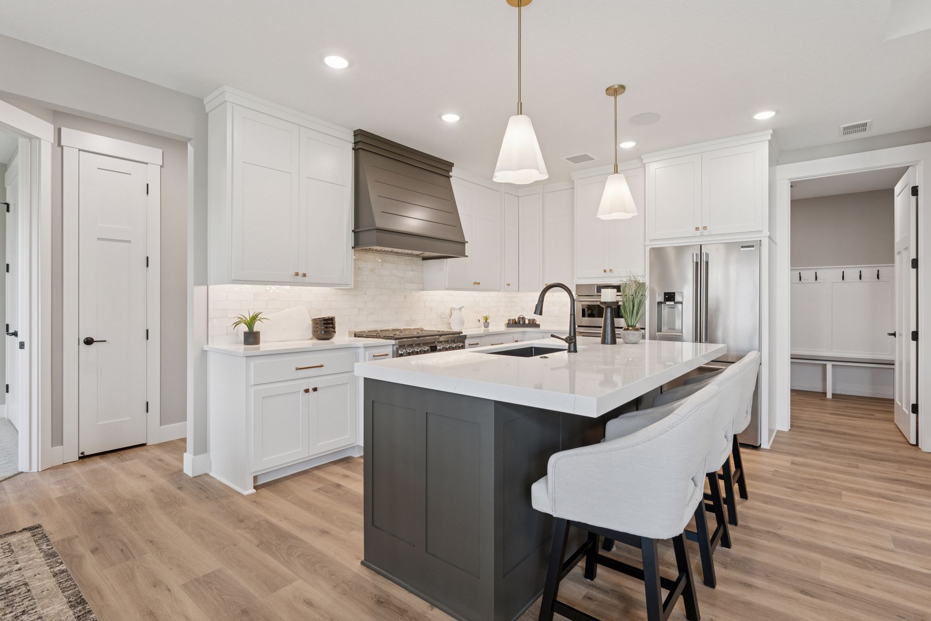 Bright modern kitchen with white finishes, colorful accents, and wood floors