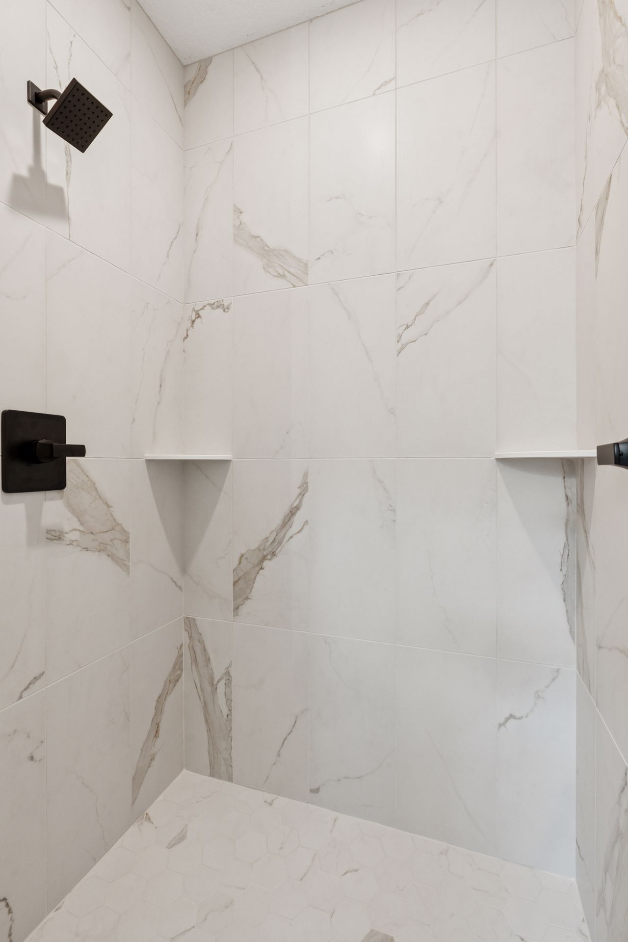 Walk-in tile shower with built-in shampoo shelves