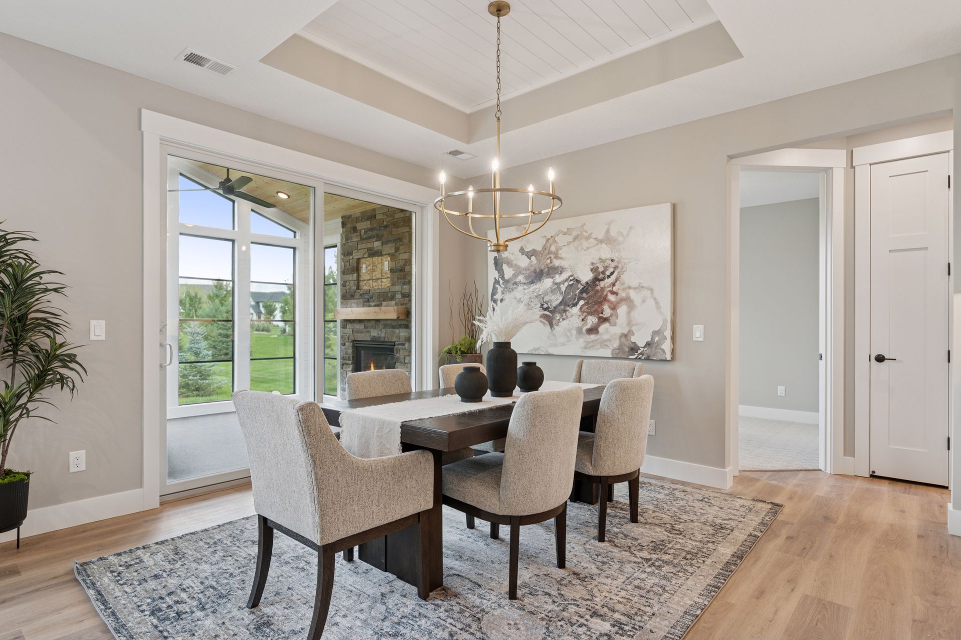 Dining room view into four-season porch with fireplace