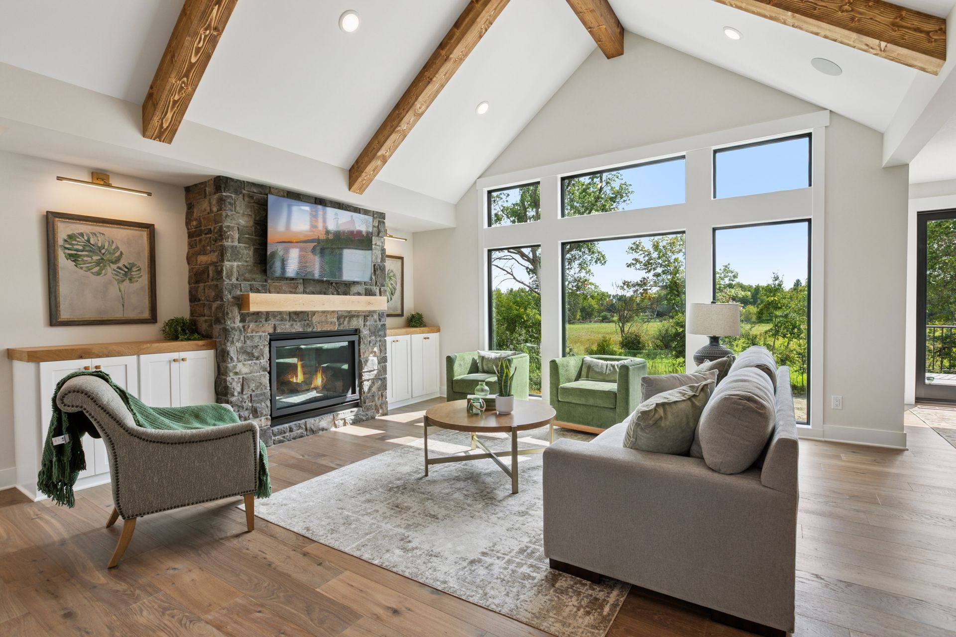 Open great room layout with wood flooring and large windows