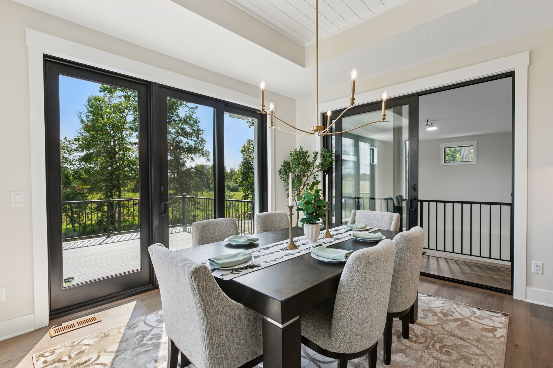 Dining area with patio doors leading to deck and Indoor Sports Room™ balcony