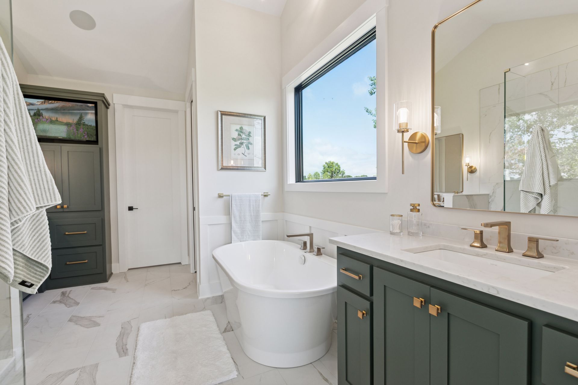 Owner’s bath with free-standing tub and large picture window view